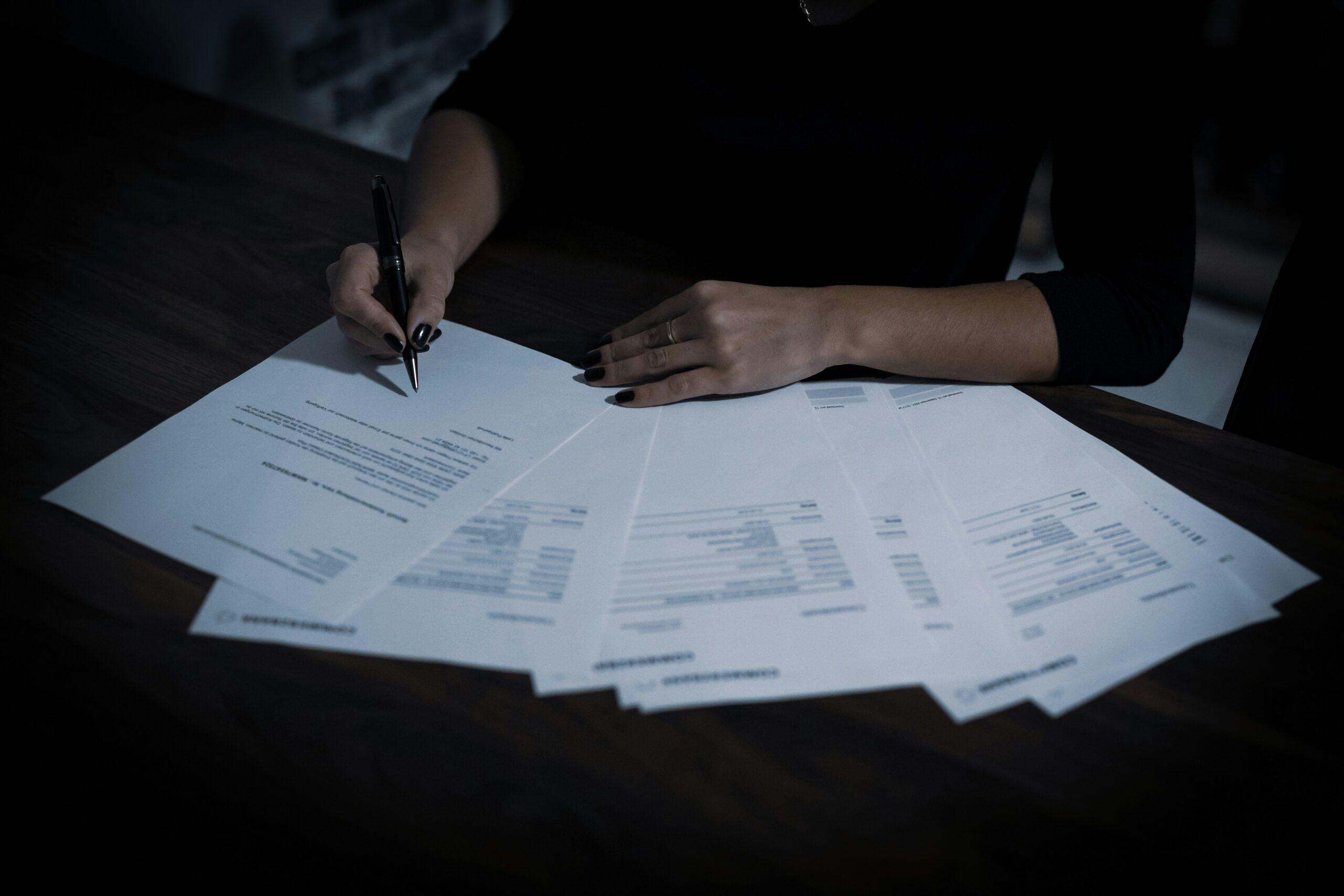 A woman sitting at a table with lots of papers